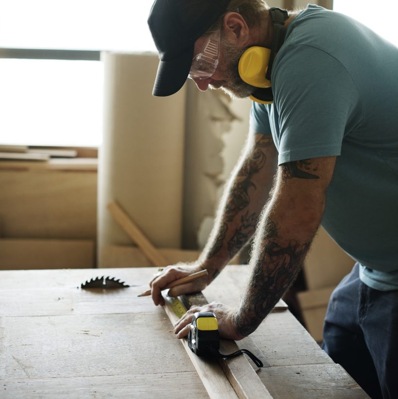 Carpenter using pencil and measurement tape on wood Carpenter using pencil and measurement tape on wood
